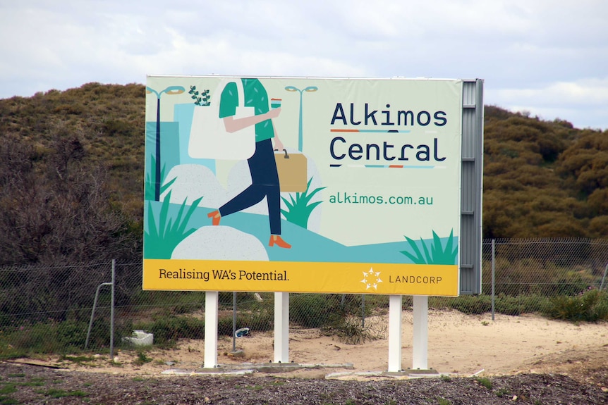 A sign advertising Alkimos Central sits on a large area of vacant land.