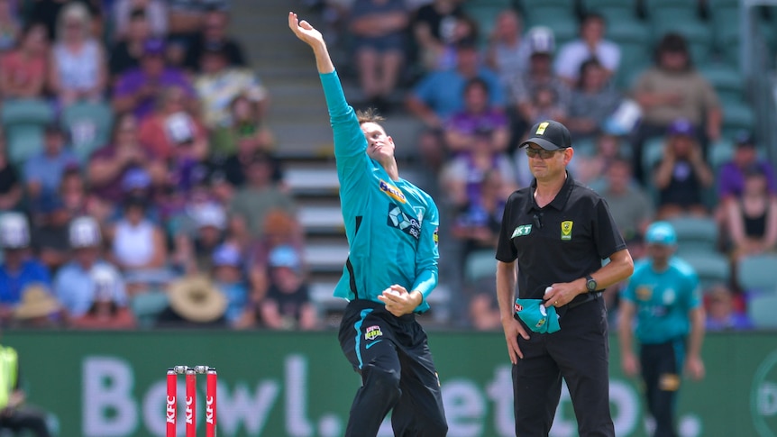 Brisbane Heat spinner Matthew Kuhnemann looks down the pitch with the ball gripped in one hand as he comes in to bowl.