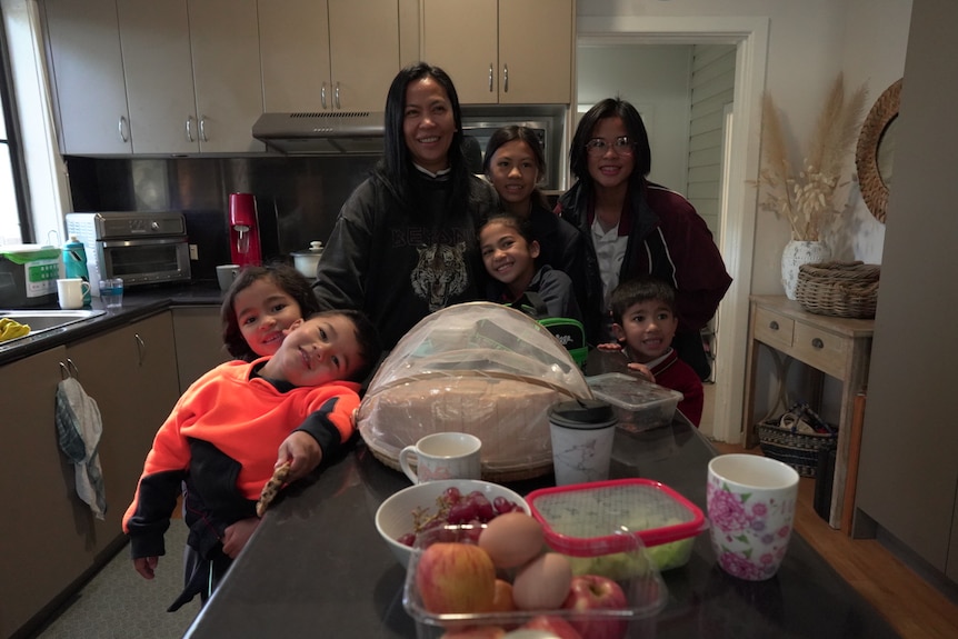 Faith Labaro and her family standing in a kitchen.
