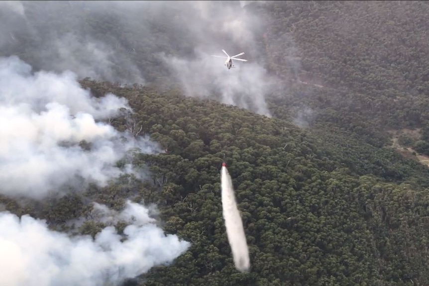 Helicopter over fire ground dropping water