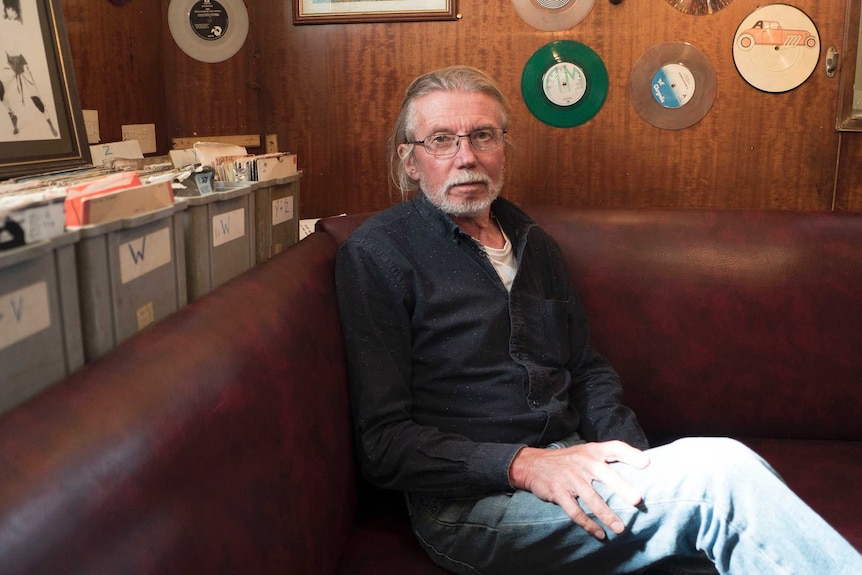 Peter Moore poses for photo on couch, onboard ship.