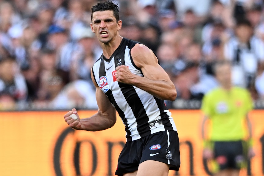 A Collingwood AFL player pumps his fists in the grand final against the Brisbane Lions.
