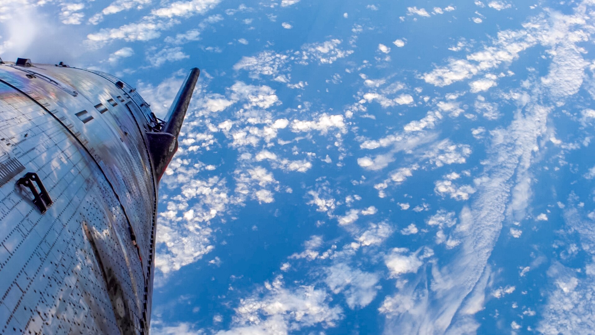 A rocket in the foreground, above ocean and clouds.