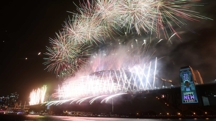 a bright fireworks display on the harbour bridge shot from a low angle