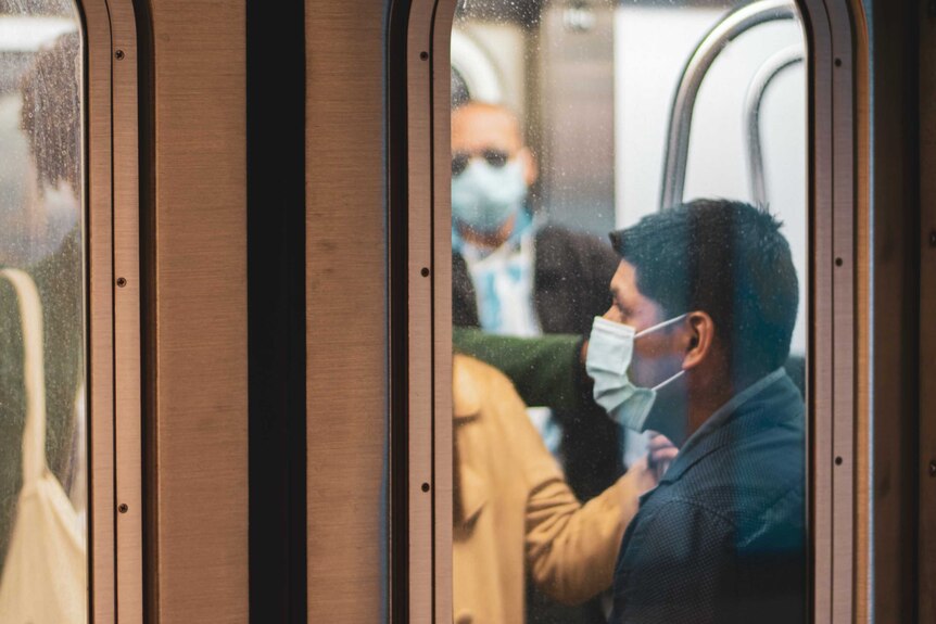 Passengers on a train wear masks during the COVID-19 pandemic.