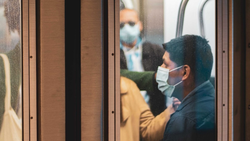 Passengers on a train wear masks during the COVID-19 pandemic.