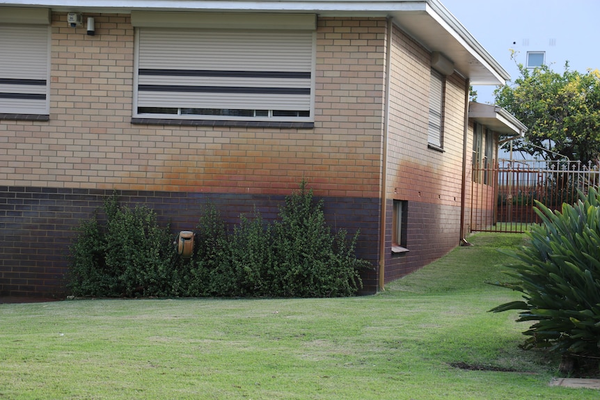 An older style house with bore water stains on its walls