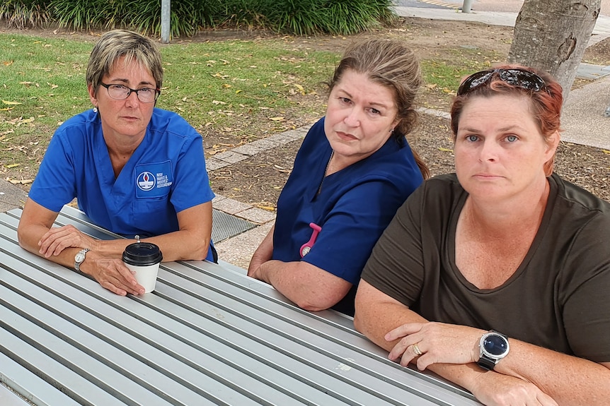 Four hospital nurses sitting around a park bench to tell their stories about working throughout the pandemic. Gosford NSW 2022