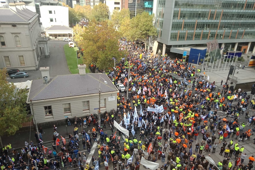 A large crowd of people march through Melbourne's CBD protesting for an increase to the minimum wage