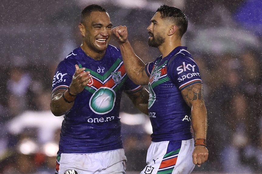 Two Warriors NRL players celebrate during their win over Cronulla.
