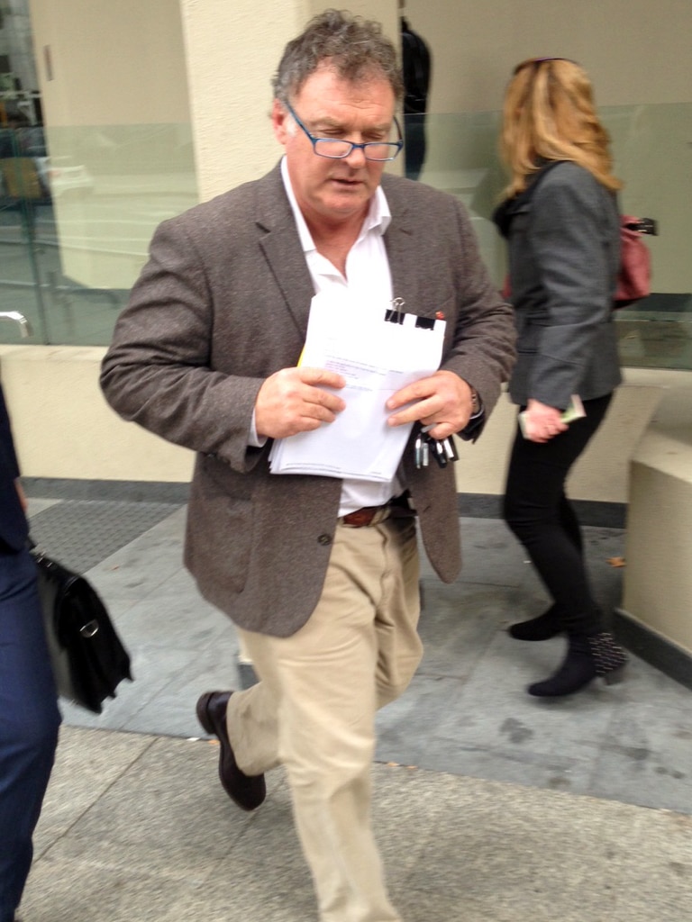 Road Culleton walking out of a Perth court holding papers.