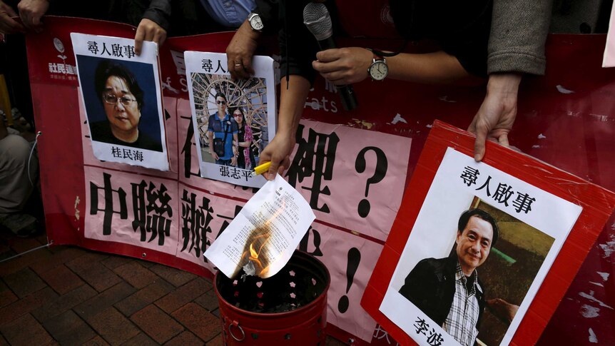 A pro-democracy demonstrator burns a letter.