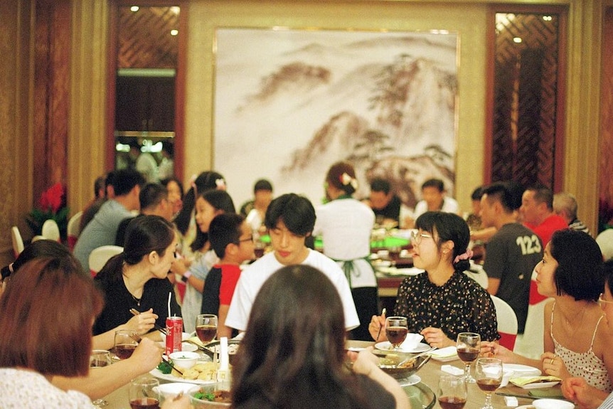 Maggie Zhou and her family share a meal together in a busy restaurant in China, where most of her relatives still live.