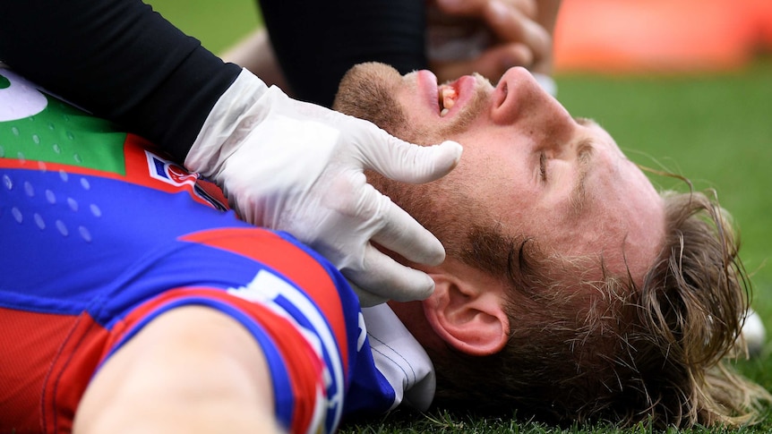 NRL player Brendan Elliot receives attention from a trainer for concussion in March, 2017.