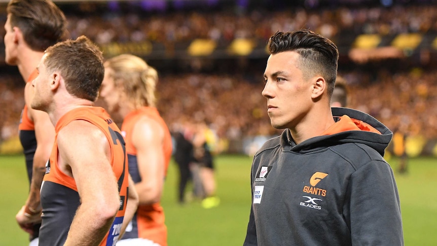 Dylan Shiel, wearing his GWS tracksuit having been ruled out of the game injured, has a sad look on his face after the game.