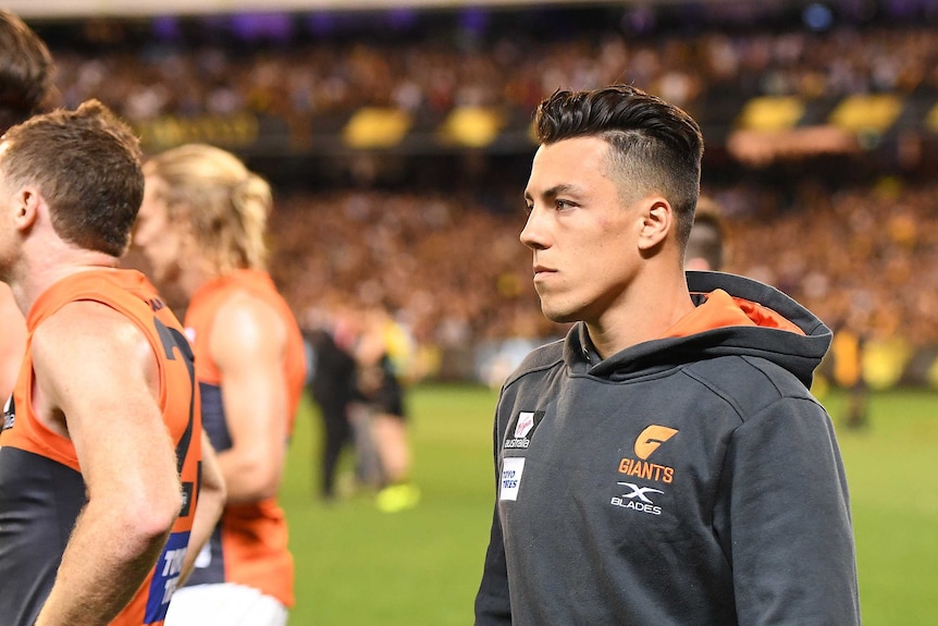 Dylan Shiel, wearing his GWS tracksuit having been ruled out of the game injured, has a sad look on his face after the game.