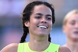 An Australian female sprinter smiles after winning the 200 metres at the national track and field championships.