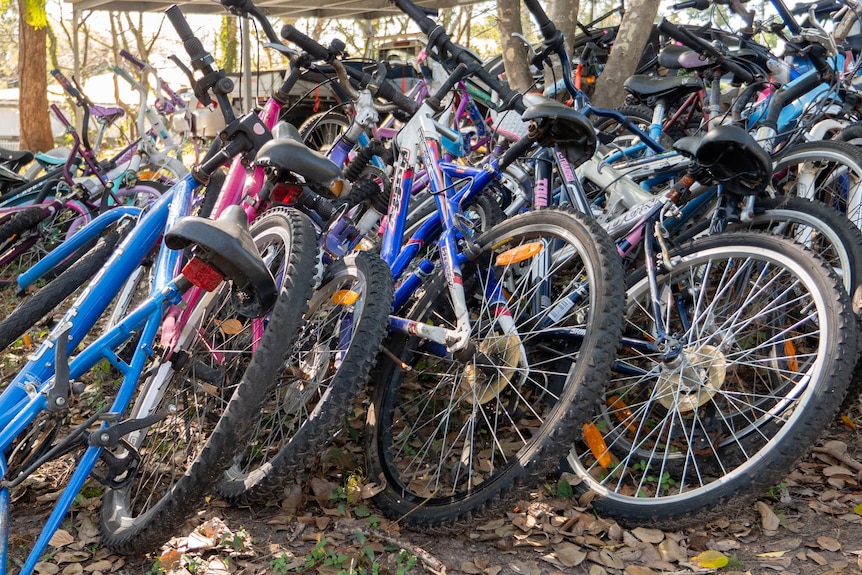 A pile of bikes lay stacked together.