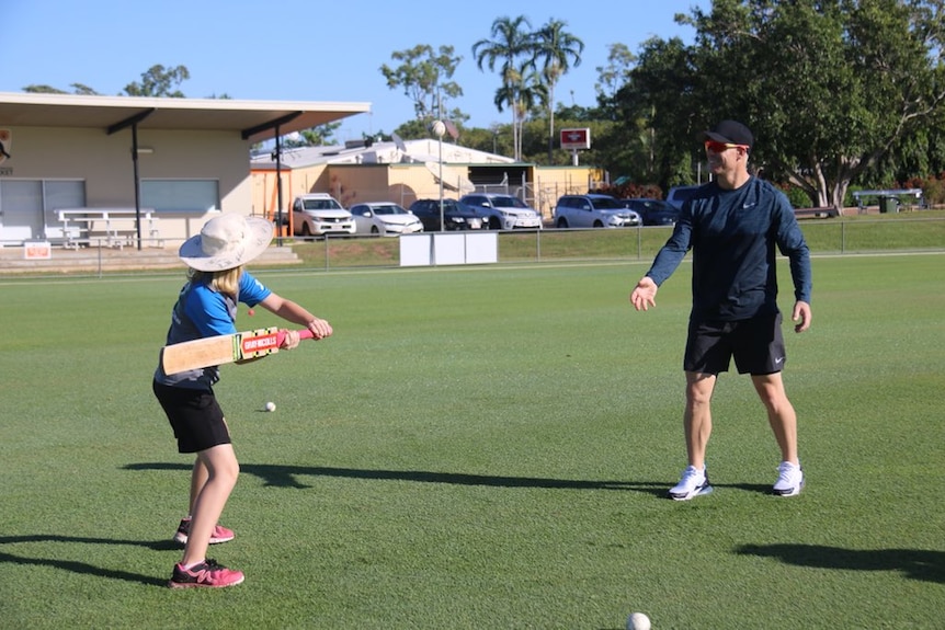 David Warner throws a ball to a young girl in Darwin.