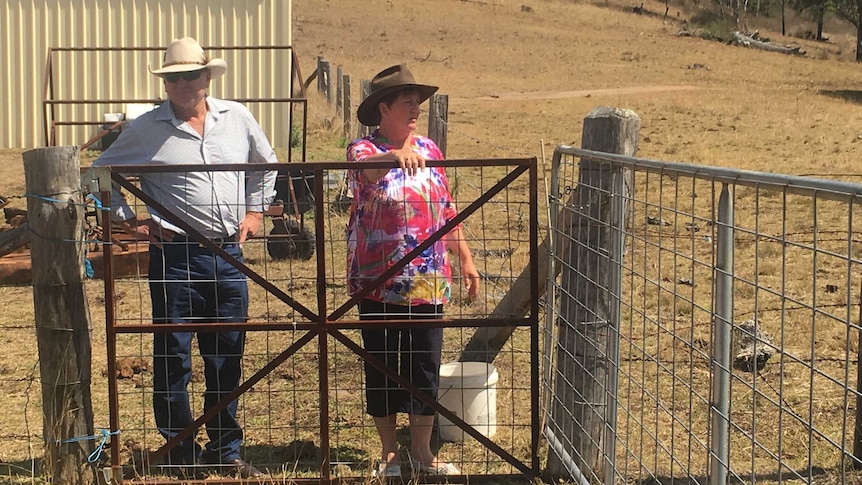 Michael and Leanne Murphy stand at a fence on their farm.