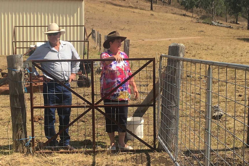 Michael and Leanne Murphy stand at a fence on their farm.