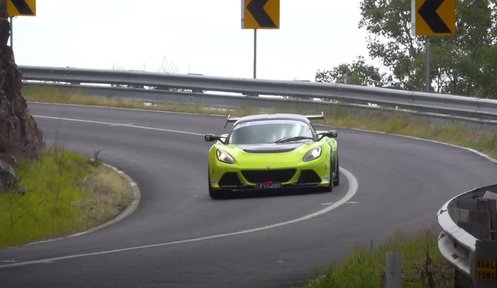 Green racing car on winding road.