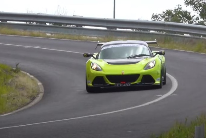 Green racing car on winding road.