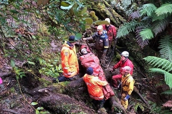 An SES crew performing a rescue with a man on a spinal board