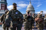 Troops stand in front of the US Capitol building.
