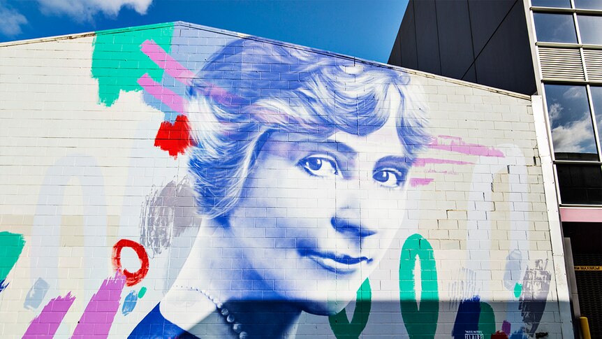 A colourful mural of a woman is painted on the wall of a building in Adelaide.