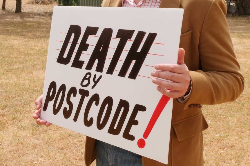 Un hombre parado en un molde en blanco con un cartel que dice Muerte con un código postal