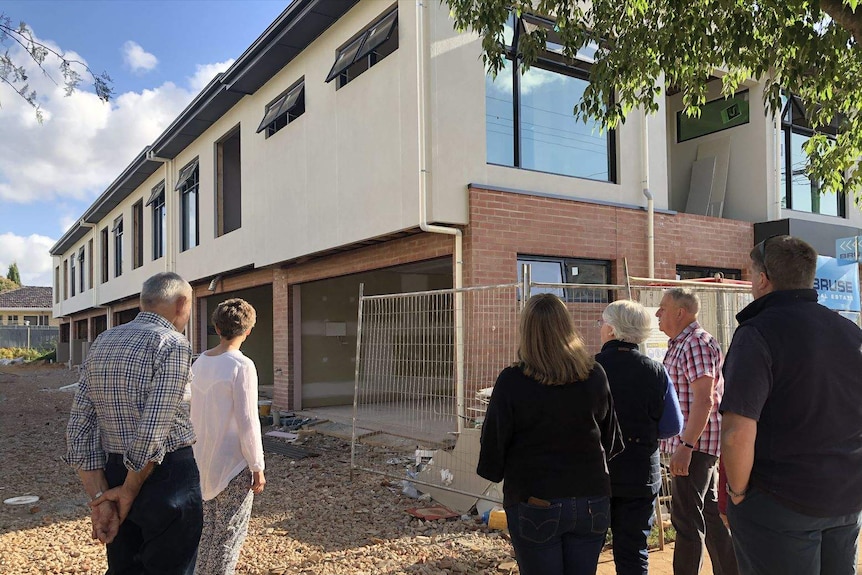 A group of residents looking at a new housing development