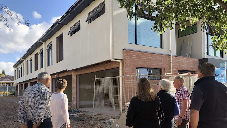 A group of residents looking at a new housing development