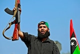 A Libyan rebel fighter celebrates as they drive through Tripoli's Qarqarsh district on August 22, 2011.