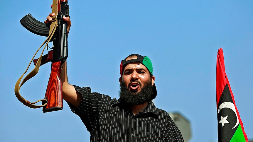 A Libyan rebel fighter celebrates as they drive through Tripoli's Qarqarsh district on August 22, 2011.