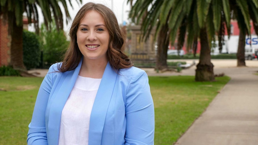 Amelia Bernasconi in a town park with grass and trees in the background.