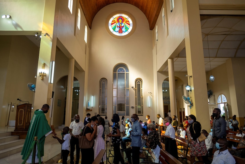 The interior of a church where people are attending mass. 