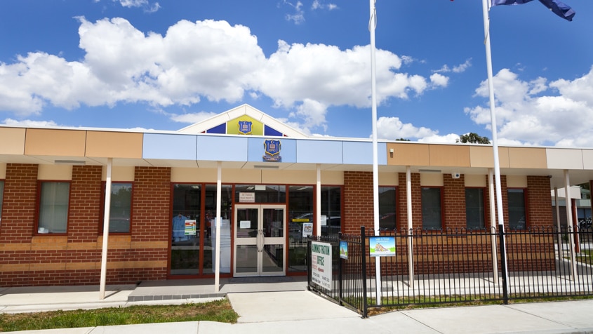 East Preston Islamic College building with flags flying above on a cloudy day