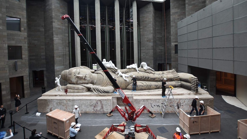 A 16-metre-long Buddha covered in classical sculptures is installed at the NGV.