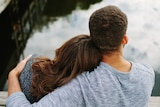 Photo taken from behind of a man with his arm around a woman