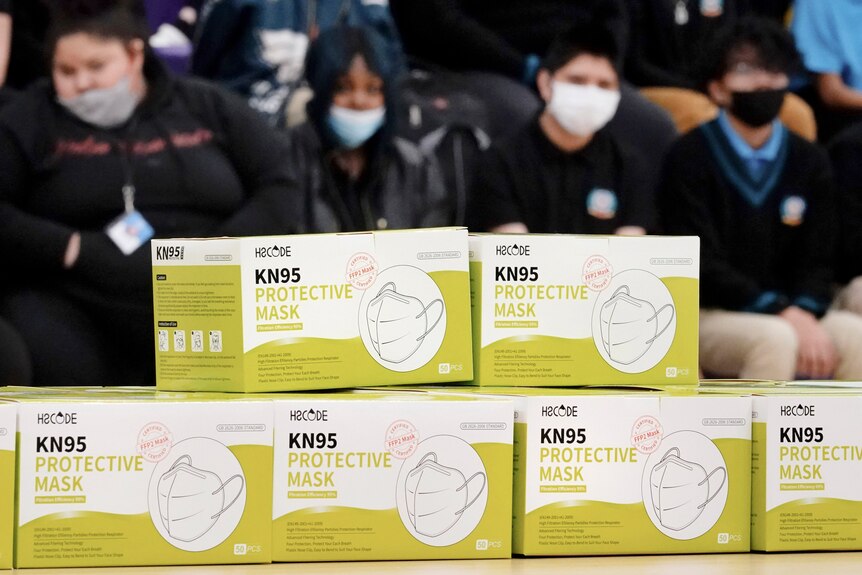 US school students sit in front of a display for KN95 masks