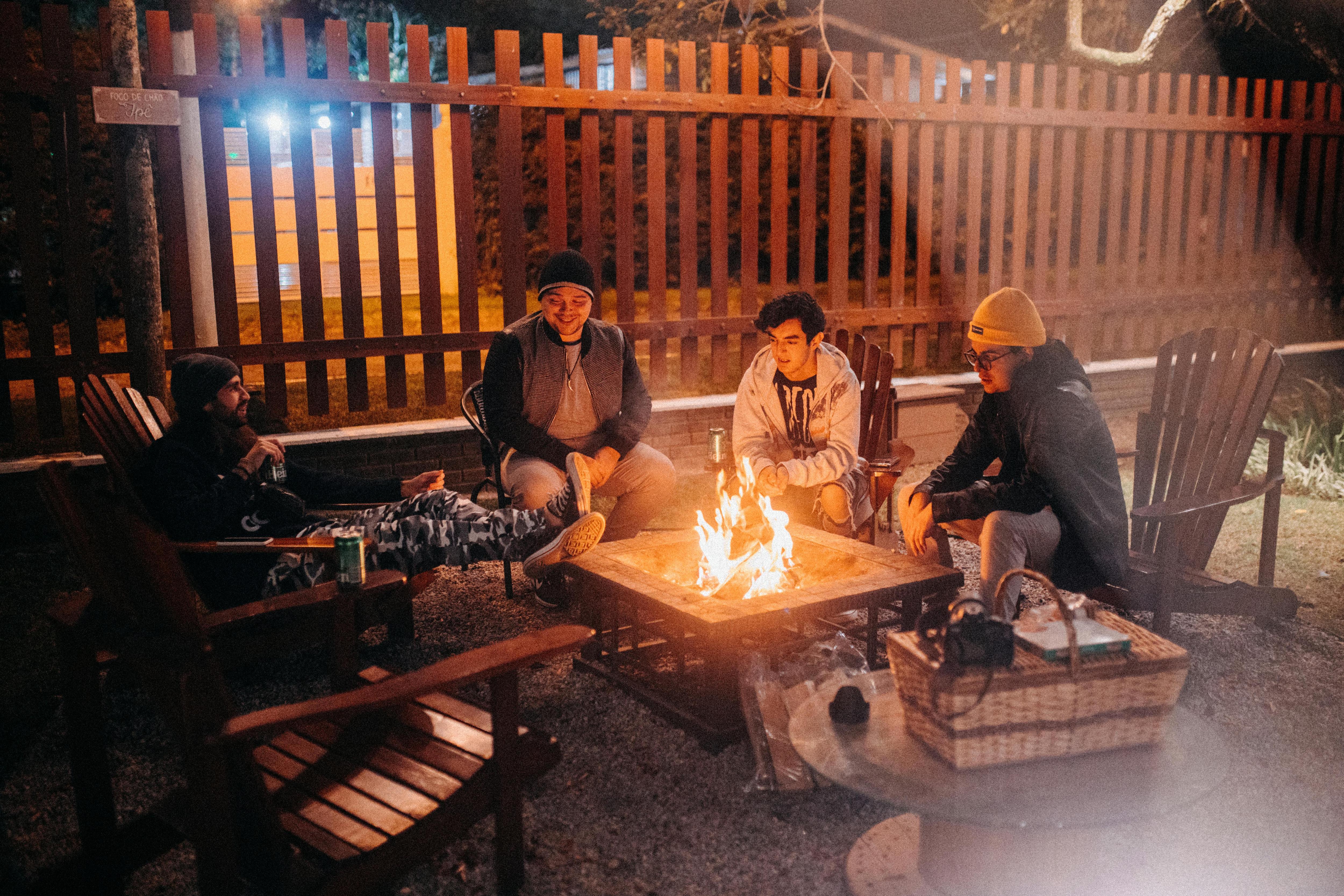 men sitting around fire pit