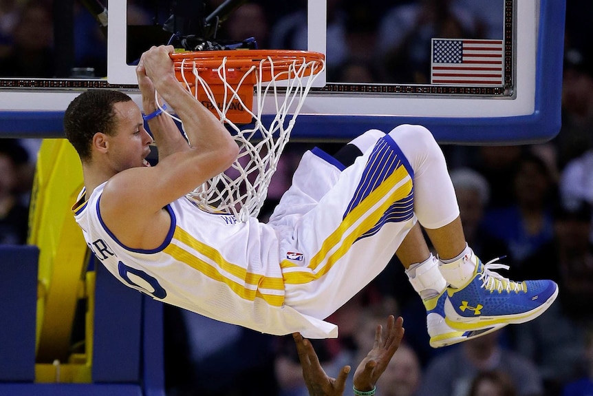 Stephen Curry hangs on the basket