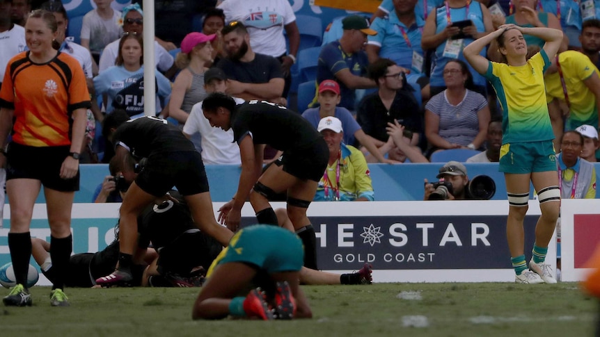 New Zealand players celebrate after defeating Australia in extra time to win rugby sevens gold medal.