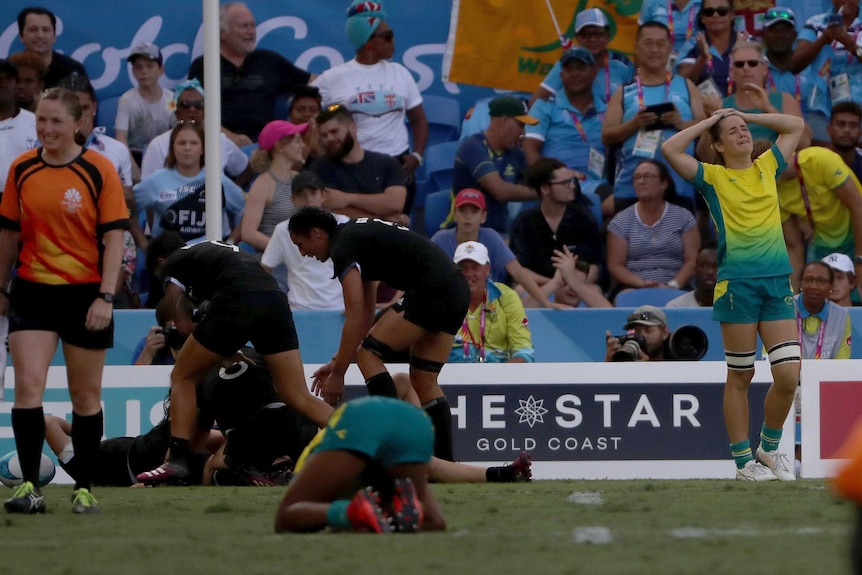 New Zealand players celebrate after defeating Australia in extra time to win rugby sevens gold medal.