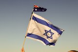 An Israeli and Australian flag wave among large group of Jewish community
