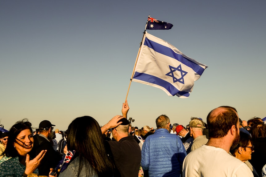 An Israeli and Australian flag wave among large group of Jewish community