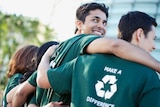 Four people wearing green T-shirts that say "make a difference".