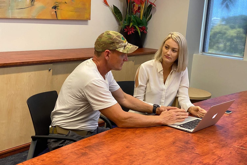 Tim Thomas and Dr Madeline Romaniuk work on the M-CARM questionnaire on a laptop in an office.