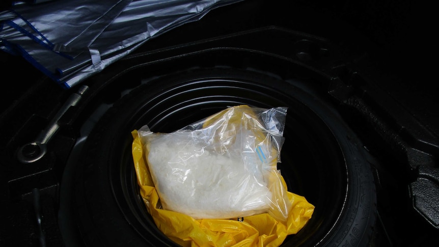 A kilogram of ice in a bag inside a car wheel, which is sitting in the boot.